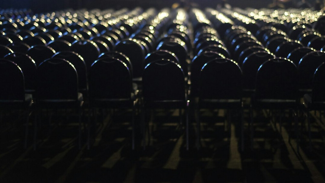 Rows of empty theater seats in dim lighting